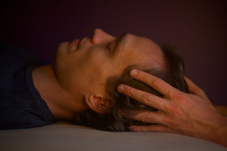 hands lightly touching around crown area of head